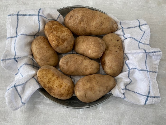 Stainless Steel Mandolin With Half A Peeled Potato On Top Stock