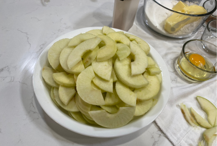 Place the sliced apples in pie pan