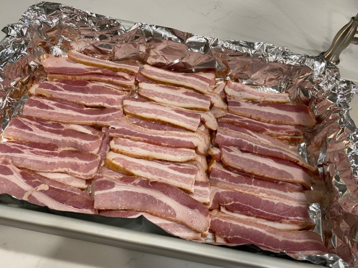 Place the bacon evenly in the pan
