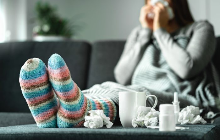 Sick woman with Influenza sitting on a couch