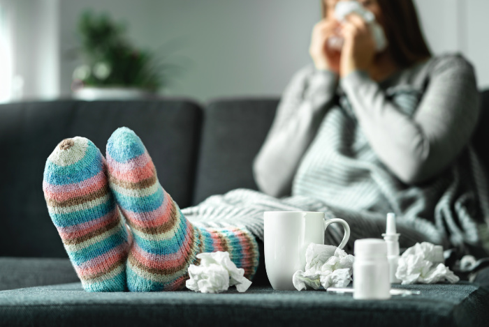 Sick woman with Influenza sitting on a couch