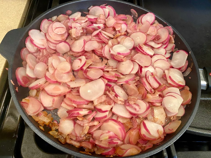 Radishes on top of bacon and onions