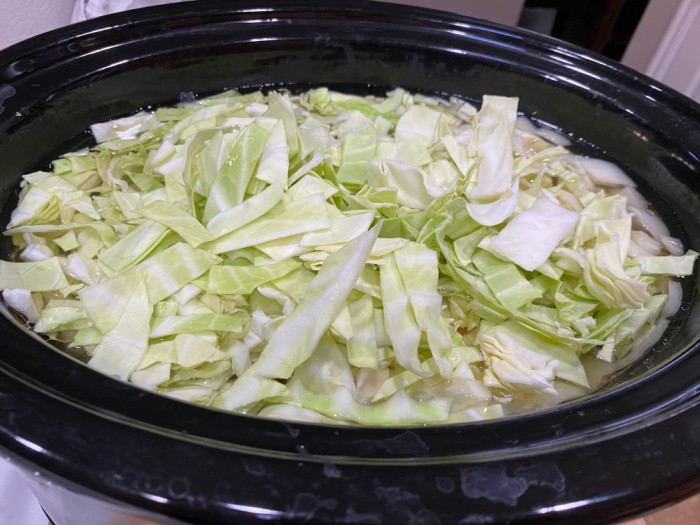 Adding the cabbage to the slow cooker
