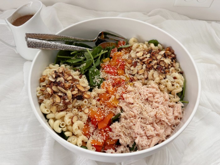 Spinach Past Salad With Chicken in a Bowl with Salad Dressing On the Side.