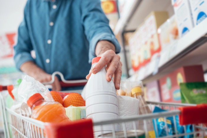 Man Putting Milk In Cart