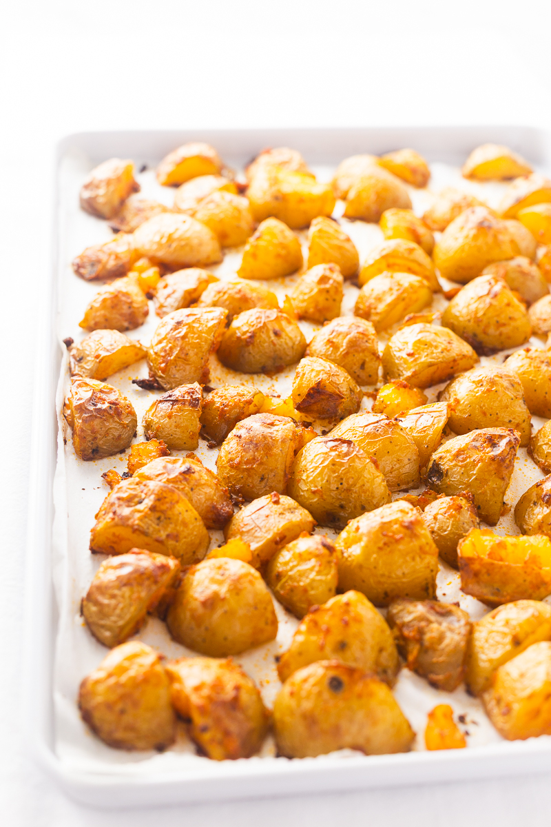 Golden brown and Crispy Oven Roasted Potatoes Recipe spread out on a baking sheet after being baked at 425 degrees.