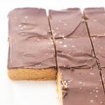 Sliced no bake peanut butter bars showing thick oat base and chocolate topping.