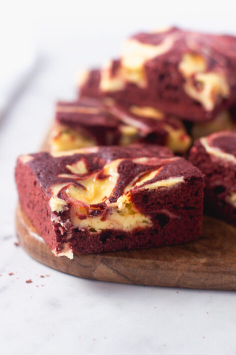 Close-up of a Red Velvet Cheesecake Brownie showing the intricate marble pattern of the cheesecake filling baked into the red cocoa batter.